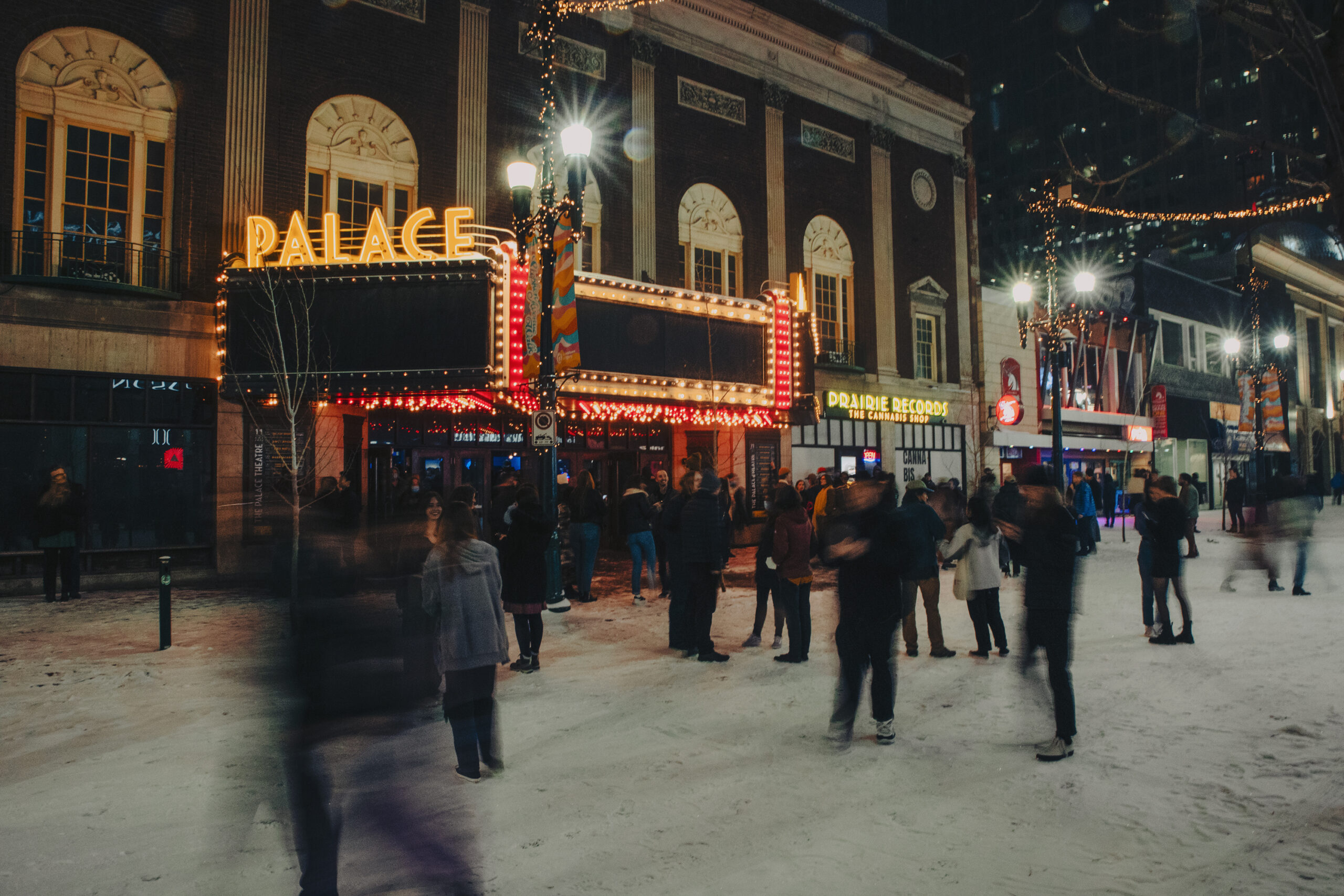 Audience members exit the Palace Theatre into the snowy night.