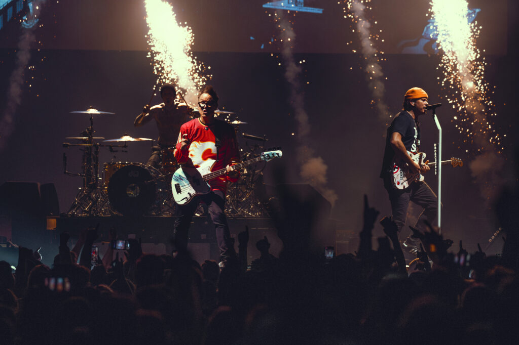 Pyrotechnics go off behind Blink 182 as they perform.